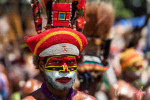 Portrait: Western Highland Man in face paint and red hat, Mt Hagen Cultural Show, PNG