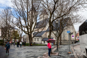Woman in red in the rainy courtyard outside St. Marys Church, Bergen Norway