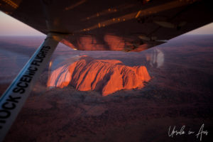 Aerial view of Uluru under the wing of a small plane, Yulara NT Australia