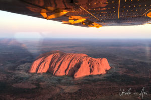 Aerial view of Uluru under the wing of a small plane, Yulara NT Australia