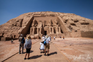 People on the path to the seated Colossi outside the Great Temple, Abu Simbel Egypt