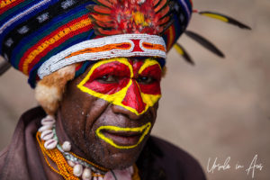 Portrait: Smiling Western Highlands Kunai man in a hat and face paint, Mt Hagen PNG.