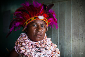 Portrait: Western Highlands woman in a pink-feathered headdress, Mt Hagen PNG.