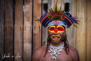 Portrait: Smiling Western Highlands Kunai man in a hat and face paint, Mt Hagen PNG.