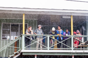 Papuans and tourists on a balcony in the rain, Mt Hagen PNG.