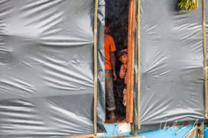 Papuan child in a plastic-coated doorway, Mt Hagen PNG.