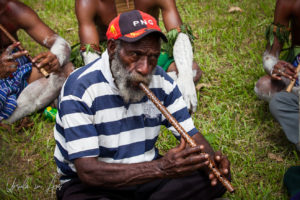 Moikep man playing a bamboo flute, Mt Hagen, Papua New Guinea