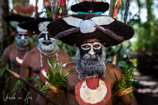 Portrait: Three Tambul men in black and white face paint, Paiya Village Papua New Guinea
