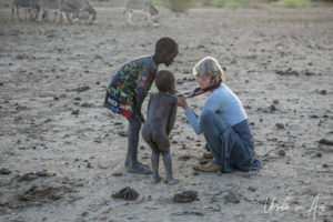 Blond woman with two Nyangatom children, Omo Valley Ethiopia
