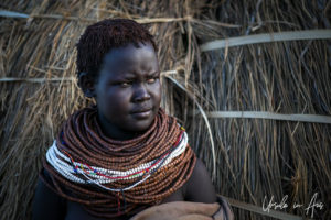 Portrait: Nyangatom Woman in brown and white beads, Omo Valley Ethiopia