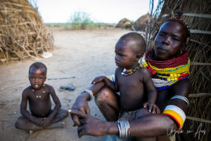 Woman and small children outside a Nyangatom home, Omo Valley, Ethiopia