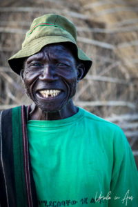 Portrait: Nyangatom man in a green t-shirt and hat, Omo Valley, Ethiopia