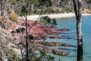 View down over the red rocks on Barmouth Beach from Haycock Point walking track, NSW Australia.