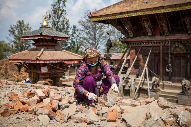 Nepali woman cleaning tumbled bricks, Changunarayan Temple, Nepal