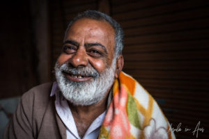 Portrait: Smiling man in an orange blanket, Haridwar India