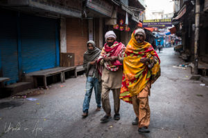 Three men walking in a Haridwar street, India