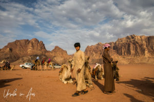Young Bedouin men, tourists and camels, Wadi Rum, Jordan