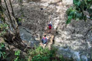 Walkers on a rough bridge over the Urubamba River at Choquesuysuy, the Inca Trail, Peru
