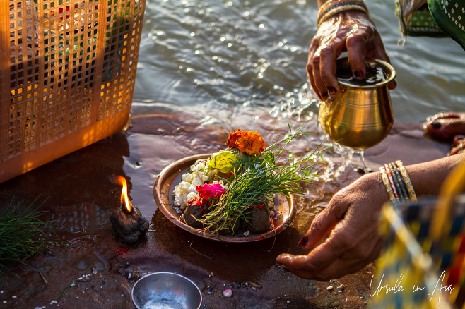 Hands with an offering of flowers and water, Varanasi, India.