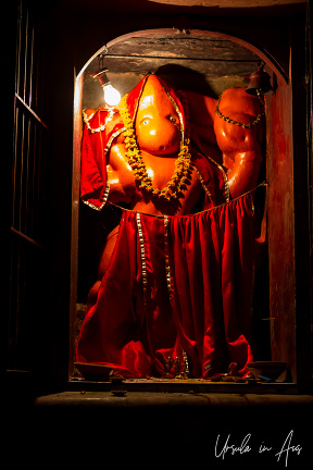 Orange figure in a shrine, Varanasi street, India