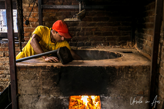 Man roasting mustard seed, Khokana factory, Nepal