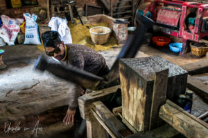 Man spinning the handles on a Newari Mustard Press, Khokana, Nepal