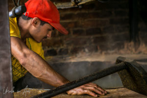 Man roasting mustard seed, Khokana factory, Nepal