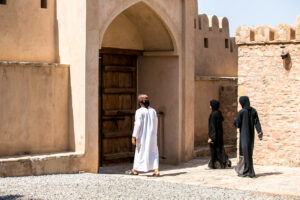 Man and two women in Omani attire, Al Hazm Castle, Oman