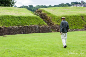 Man walking on the Roman Amphitheater at Caerleon, Wales