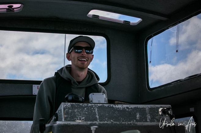 Portrait: Young man at the helm of a small ferry, Nanaimo BC Canada