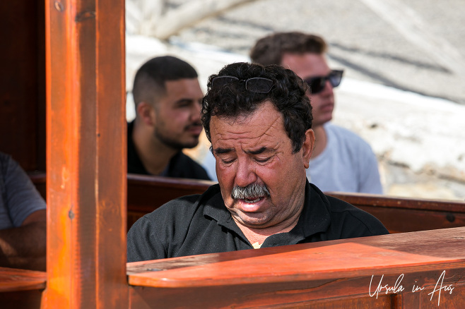 Ticket salesman in a booth, Plaka, Crete Greece.