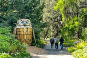 Wooden owl next to a pathway, VanDusen Gardens, Vancouver BC Canada.