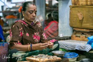 Woman peeling prawns, Goubert Market, Puducherry, Indi