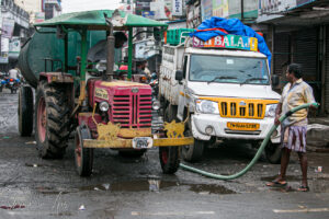 Men with a tanker truck outside Goubert Market, Puducherry, India.