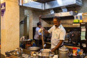 Man pouring coffee from a height, Puducherry, India.
