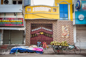 A South Indian couple sitting on the sidewalk, Pondicherry India.