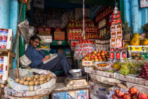Indian man sitting in a vegetable shop, Haridwar.