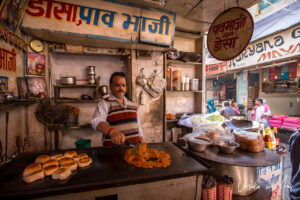 Indian man making food in a shop, Haridwar.