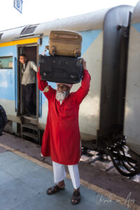 Indian porter with bags on his head, Haridwar Railway Station, India
