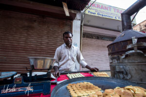 An Indian man making buns in the street, Haridwar.