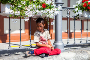 A child sitting under potted flowers, Alpnachstad PB Switzerland.
