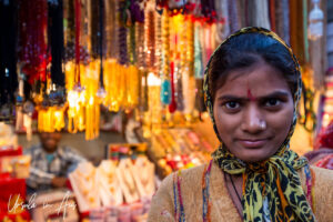 Environmental portrait: Young Indian woman in front of a gold shop, Haridwar.