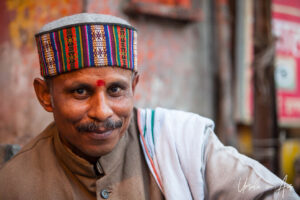Environmental portrait: Man in an embroidered felt cap, Haridwar, India