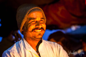 Environmental portrait: a man in a wool hat after dark, Haridwar ghats India
