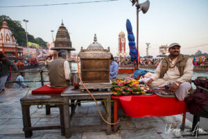 A man with a shrine and floral offerings, Har Ki Pauri, Haridwar, India