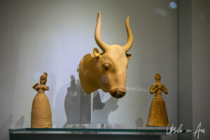 Clay bull's head rhyton and standing figurines, Heraklion Archaeological Museum, Crete Greece.