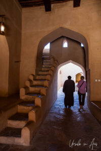 Two people silhouetted inside the entry to Nizwa Fort, Oman.