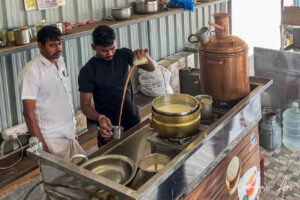 Young man making tea, with an older man watching, Ariyalur Tamil Nadu
