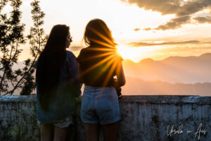 Two women silhouetted against the morning sunrise, Kunjapuri Temple, Uttarakhand, India