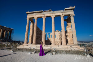 Woman in purple in front of the Erechtheion, the Acropolis, Athens, Greece.